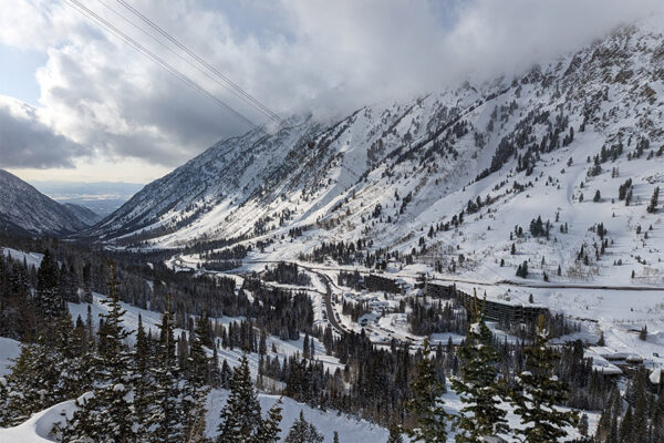 Snowy ski resort in Utah with foggy clouds and sunshine.