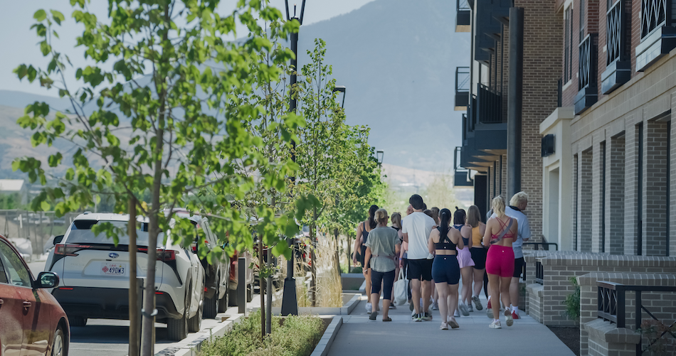 A group of people walking down the sidewalk after a workout.