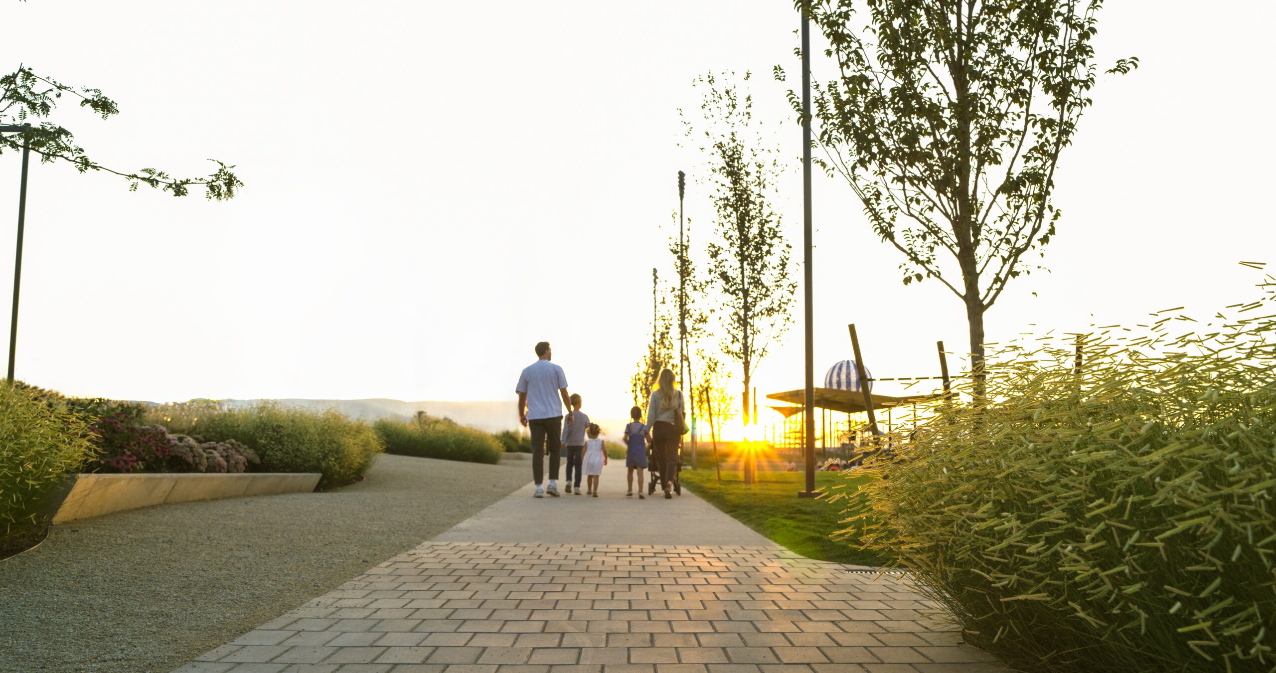 Young family walking together at dusk on the grounds of Utah City.